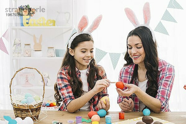 Close up Mädchen Mutter Färbung Eier Ostern nach Hause