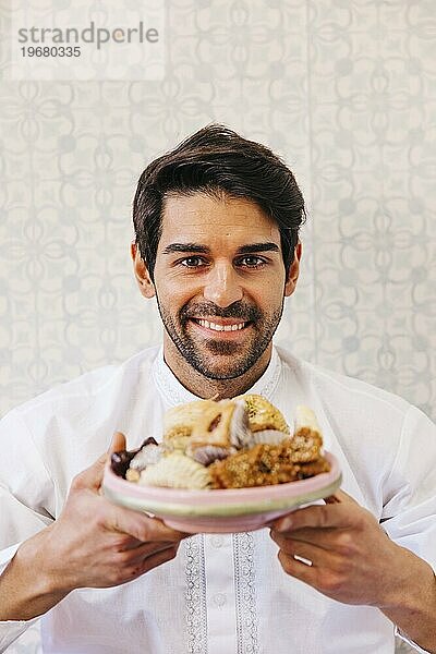 Mann hält Teller mit leckerem arabischen Essen