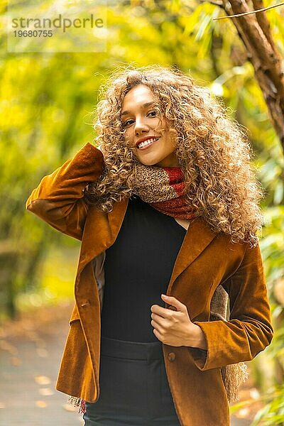 Sinnliches junges Model posiert mit warmer Kleidung in einem Park im Herbst