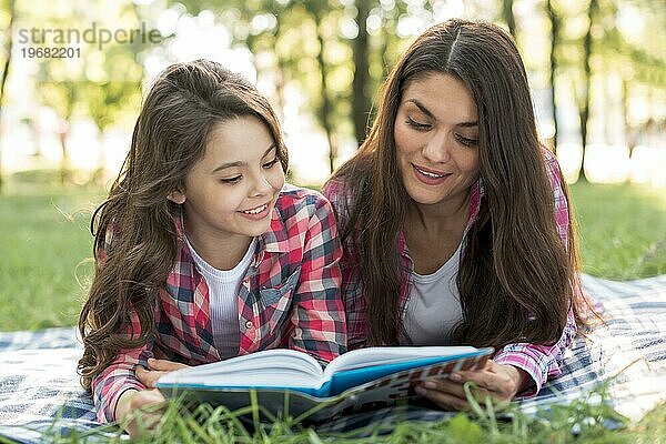 Mutter Tochter liegend Decke lesen Buch zusammen