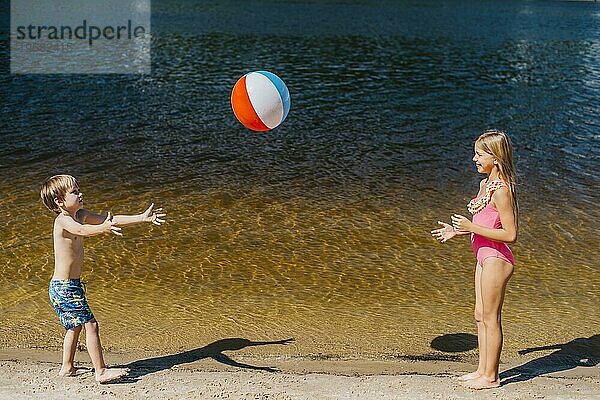 Kinder spielen mit Strandball in der Nähe des Meeres