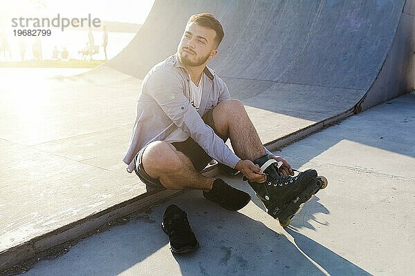 Junger Mann auf Rollschuhen im Skatepark