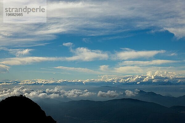 Luftaufnahme über eine schöne Berglandschaft und einen Berggipfel mit Menschen und mit schwebenden Wolken an einem sonnigen Tag im Tessin  Schweiz  Europa