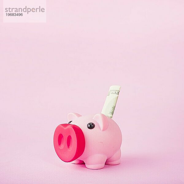 Sparschwein mit Geld rosa Hintergrund