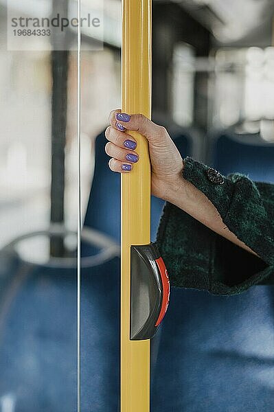 Frau hält ihre Hand bus pole