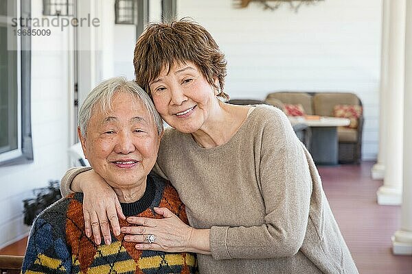 Glückliches älteres chinesisches Paar posiert für ihr Porträt auf der Veranda