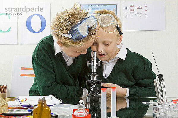 Zwei Jungen schauen in ein Mikroskop