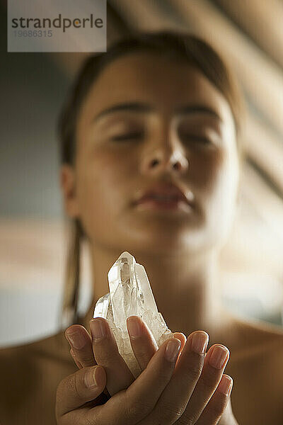 Junge Frau hält Kristall in ihren Händen