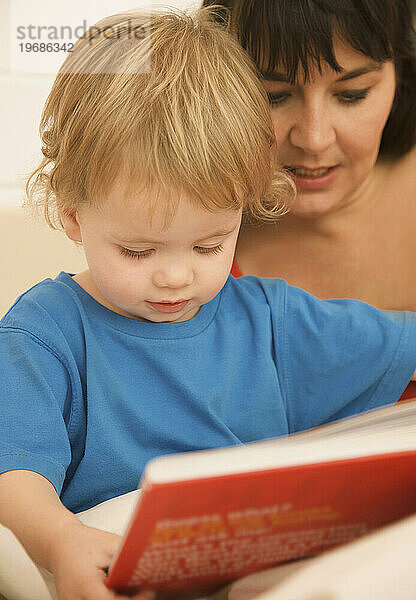 Frau mit Kind liest eine Gutenachtgeschichte vor