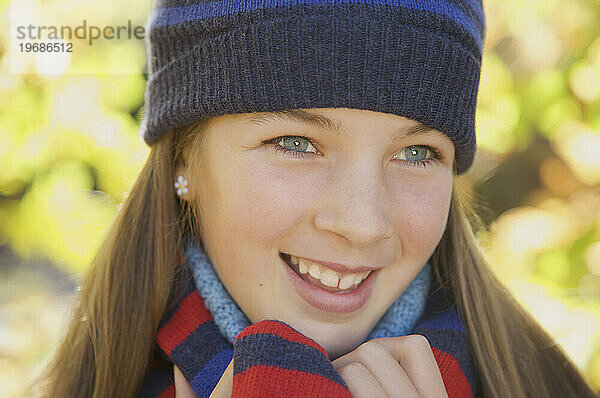 Lächelndes junges Mädchen mit Wollmütze
