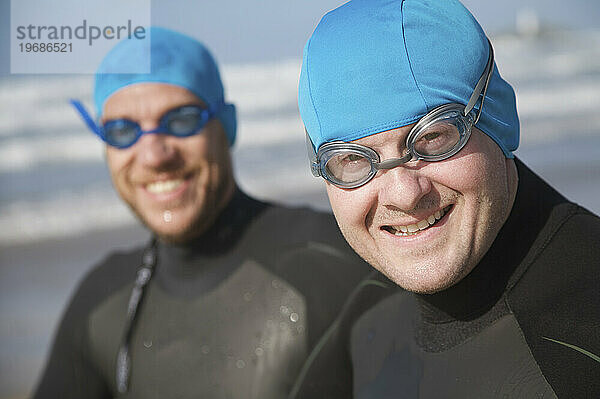 Zwei Männer mit Badekappen und Schutzbrillen lächeln