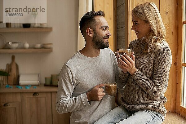 Medium Shot Liebhaber mit heißen Getränken