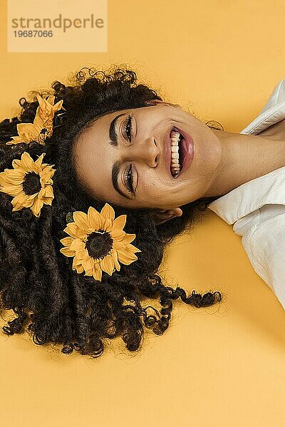 Attraktive fröhliche Frau mit Blumen Haar