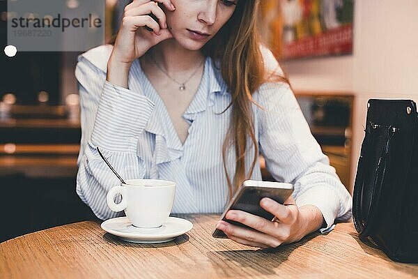 Crop Frau mit Smartphone Cafe Tisch