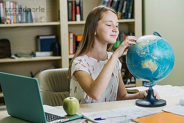 Charmante Studentin bei der Arbeit mit dem Globuspult