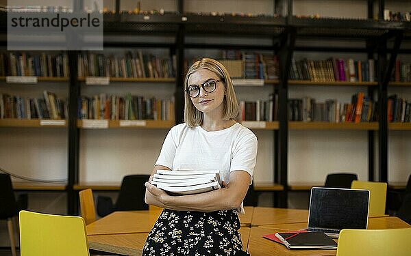 Hübsche junge Frau posiert Bibliothek