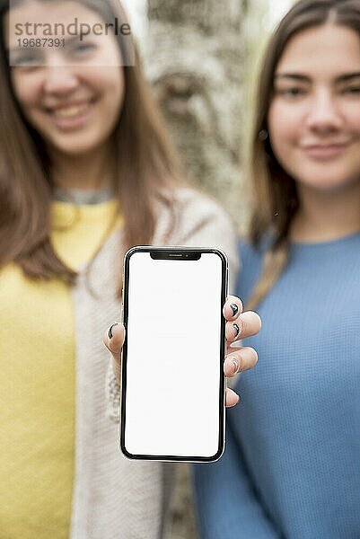 Zwei Mädchen präsentieren ein Smartphone Mockup