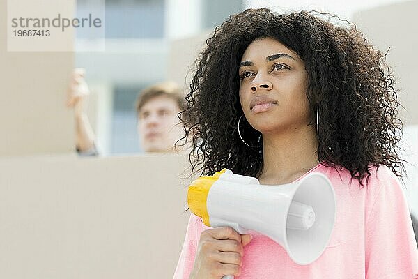 selbstbewusste Frau mit lockigem Haar  die protestiert