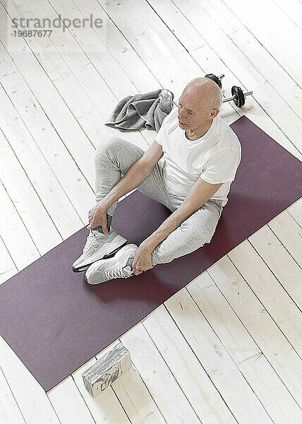 Vollbild Senior Mann sitzend Yogamatte
