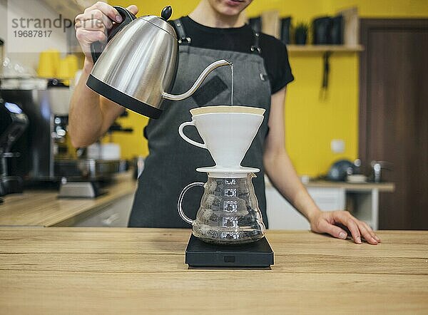 Vorderansicht weibliche Barista gießt heißes Wasser ein Kaffeefilter