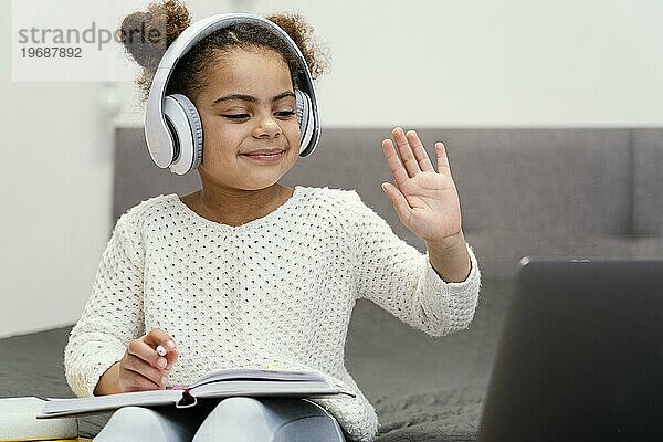 Vorderansicht kleines Mädchen winkend mit Laptop online Schule