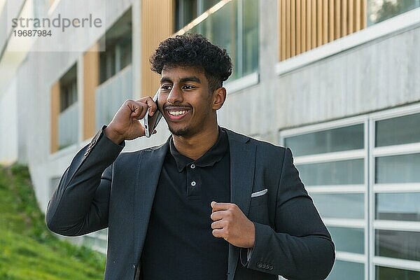 Nahaufnahme eines jungen  selbstbewussten arabischen Mannes  der im Freien telefoniert