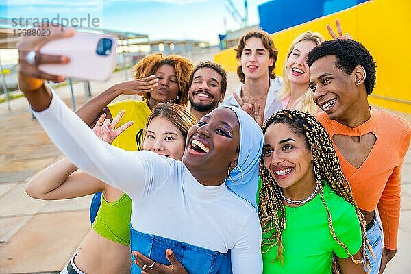 Fröhliche muslimische afrikanische Frau macht ein Selfie mit Freunden in einem städtischen Raum