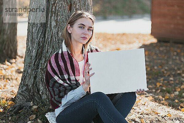 Schöne Frau hält Rahmen mit Mockup