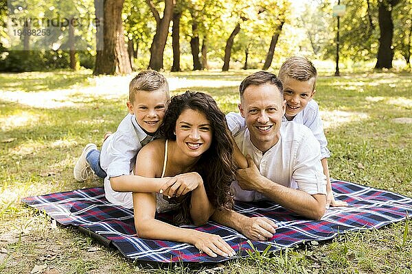 Familie posiert gemeinsam auf einer Picknickdecke