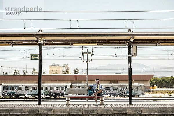 Lange Aufnahme lächelnder Reisender  der auf den Zug wartet