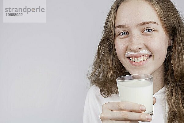 Vorderansicht blondes Mädchen hält Glas Milch