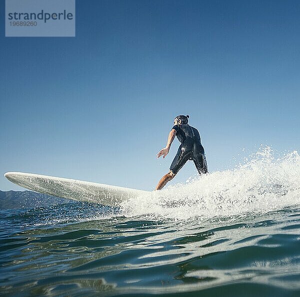 Mann auf seinem Surfbrett Seitenansicht
