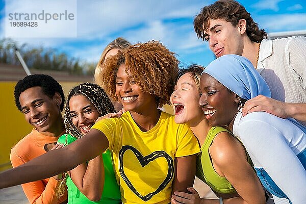 Seitenansicht einer Gruppe multiethnischer Freunde  die lächelnd ein Selfie im Freien machen