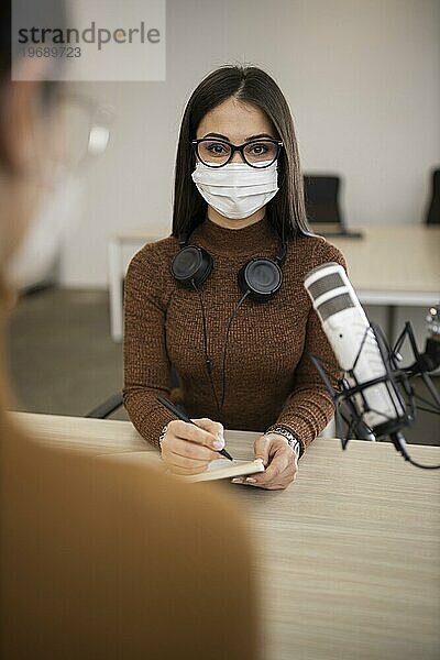 Frauen mit medizinischen Masken machen Radioshow