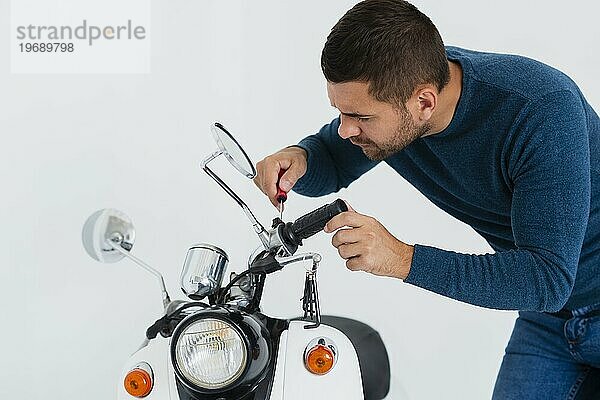 Vorderansicht junger Mann repariert Motorrad