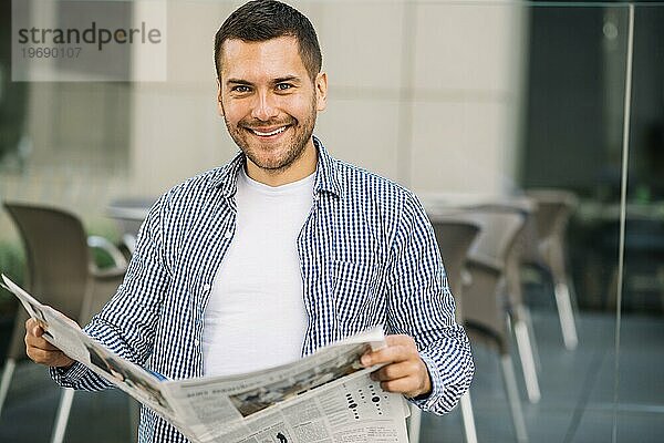 Hübscher Mann liest Zeitung im Café