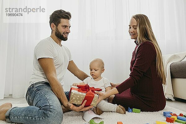 Seitenansicht Eltern zu Hause mit ihrem Babygeschenk