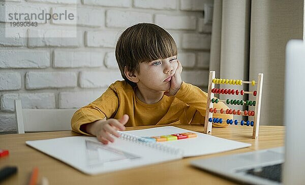 Vorderansicht Kind mit Abakus beim Lernen am Laptop zu Hause