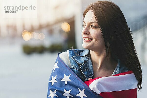 Junge Frau rollt amerikanische Flagge auf