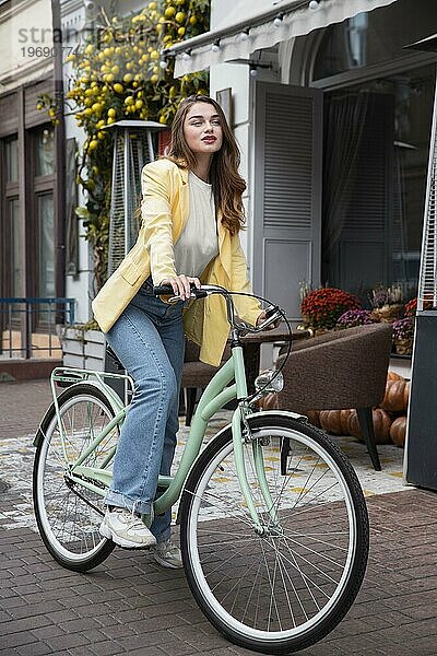 Schöne Frau mit ihrem Fahrrad Straße