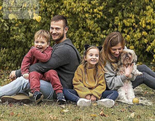 Glückliche Familie mit Hund im Freien