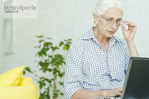Porträt ältere Frau mit Blick auf Laptop