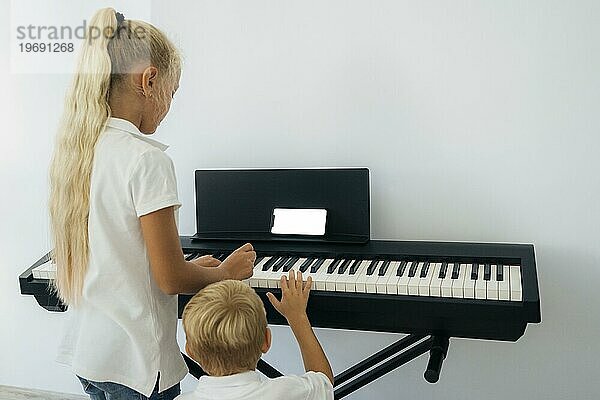 Kleine Kinder lernen Klavier spielen