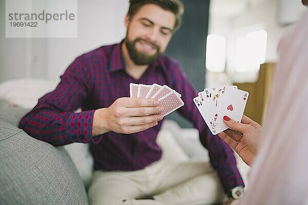 Pärchen spielt Karten Sofa zu Hause