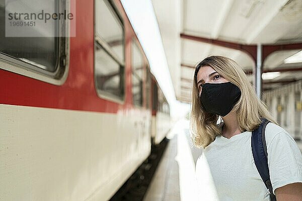Frau mit Stoffmaske im stehenden Zug