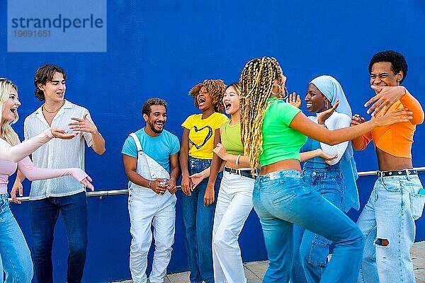 Eine Gruppe junger Leute tanzt gemeinsam im Freien auf einer multikulturellen Party