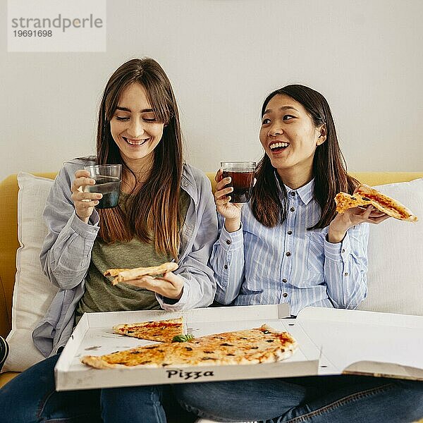 Lachende  entspannende Mädchen beim Pizzaessen