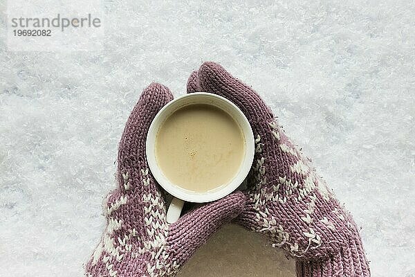 Person s Hand gemütlich Handschuh hält Kaffeetasse verschneiten Land