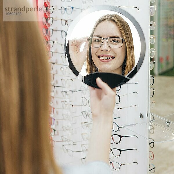 Glückliche Frau sucht neue Brille Optiker 3