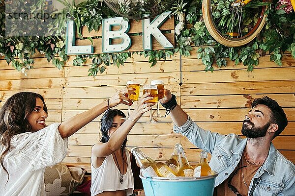 Junge Freunde stoßen mit Bier an